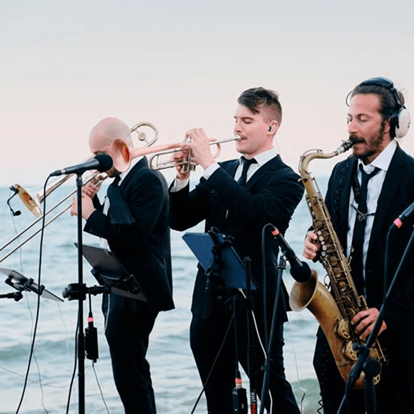 The Shuk horn section performing at a waterside wedding