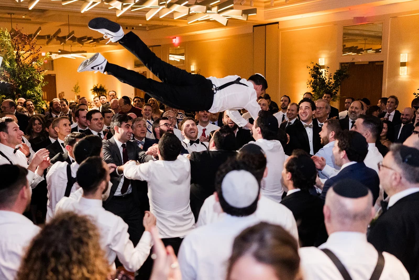 Guests lifting the groom on the dance floor